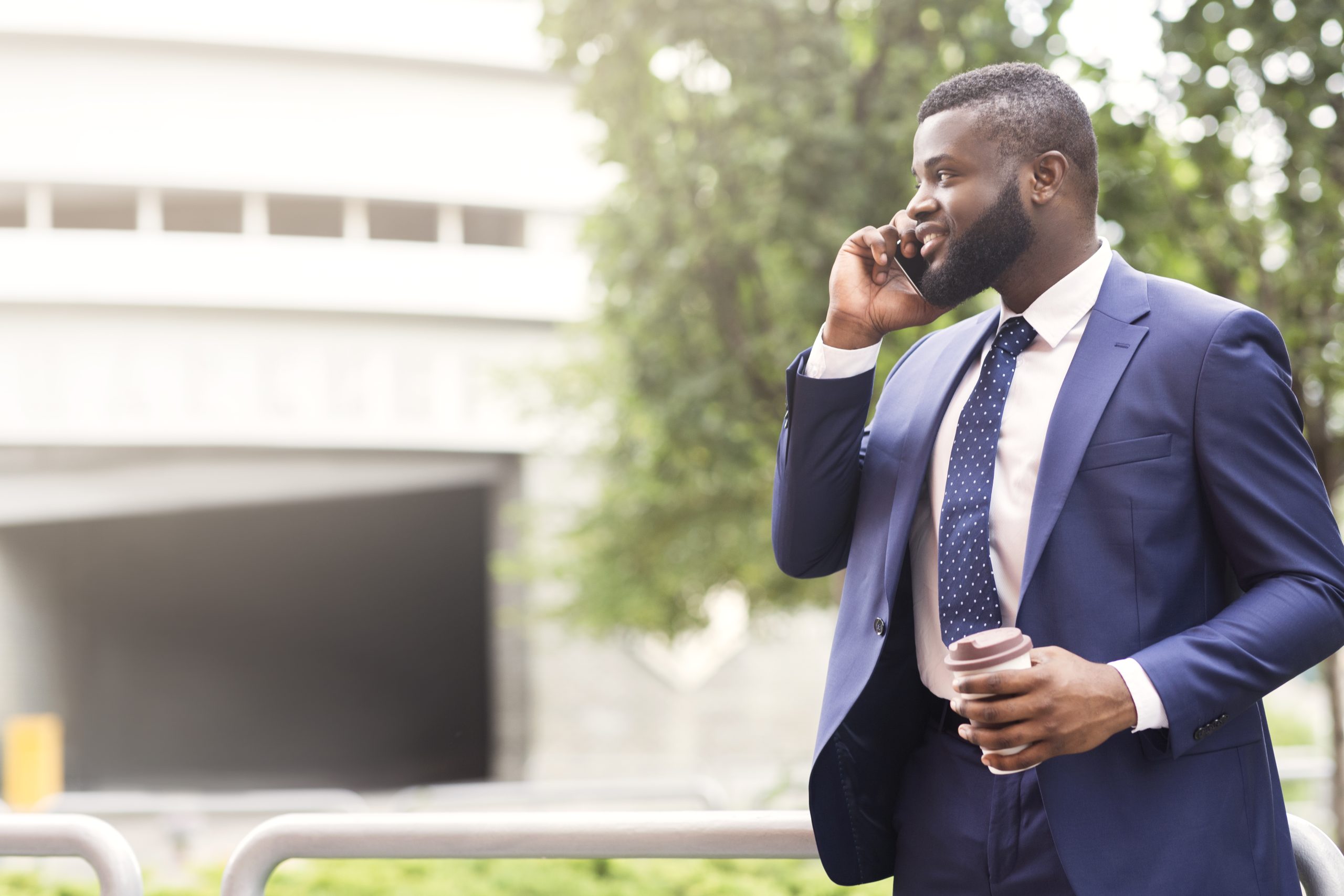 Bearded African American businessman talking on cell phone with customer