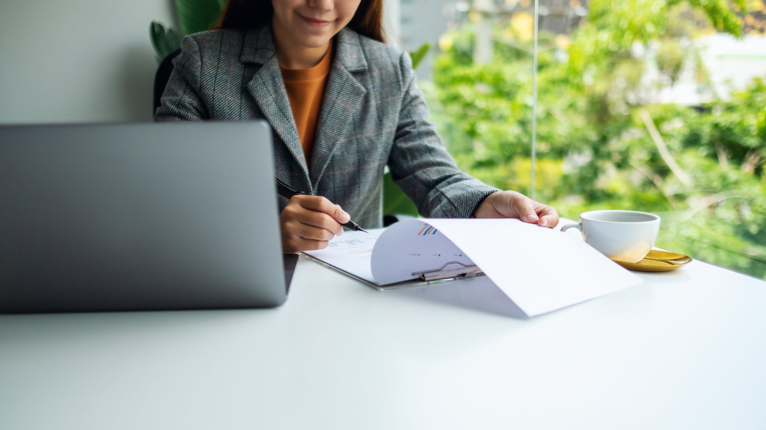 Businesswoman working on financial paperwork and laptop computer