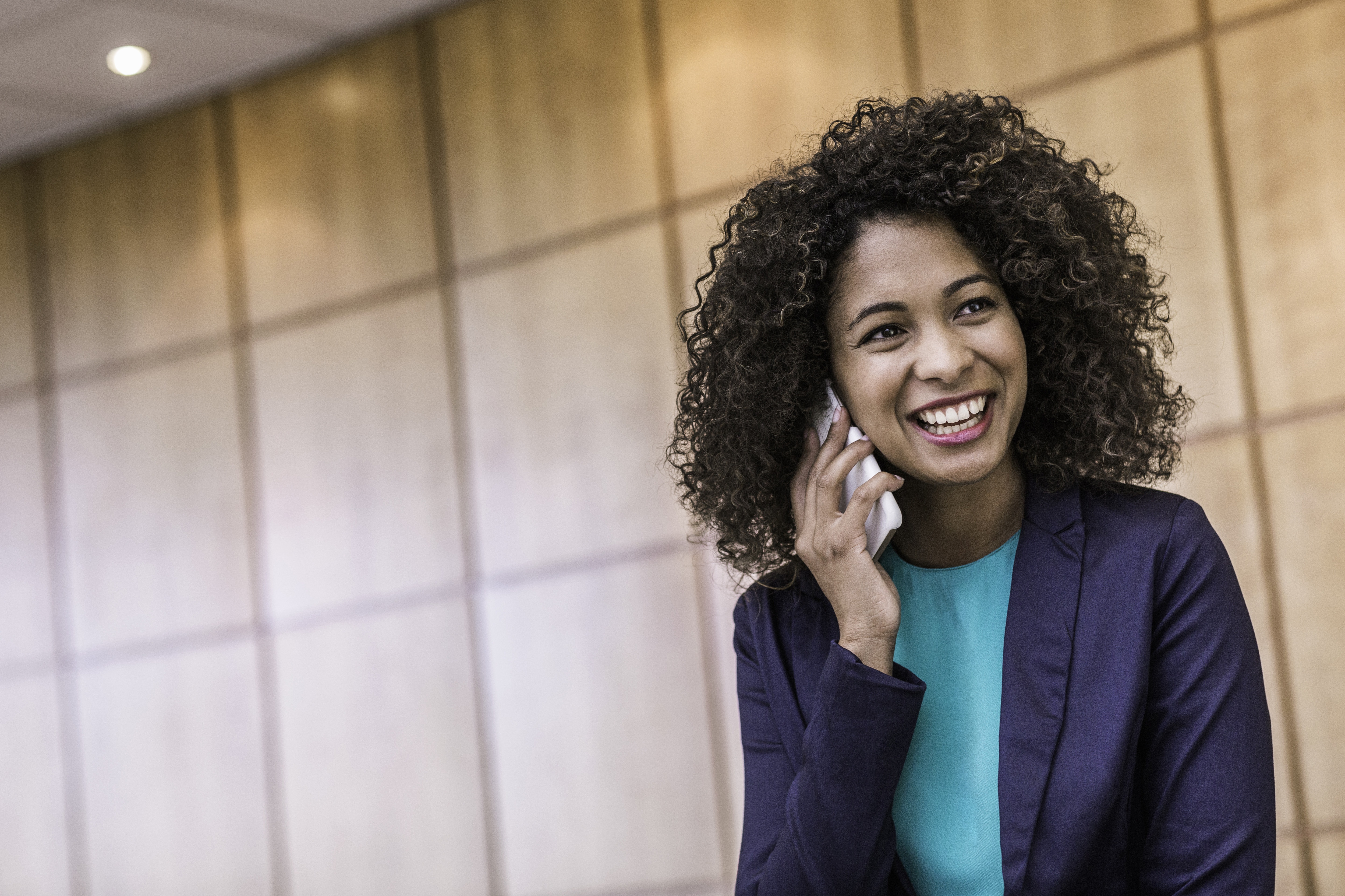 Young businesswoman talking on smartphone in office